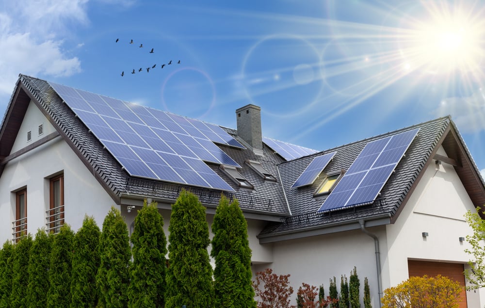 A house with traditional solar panels mounted on the roof