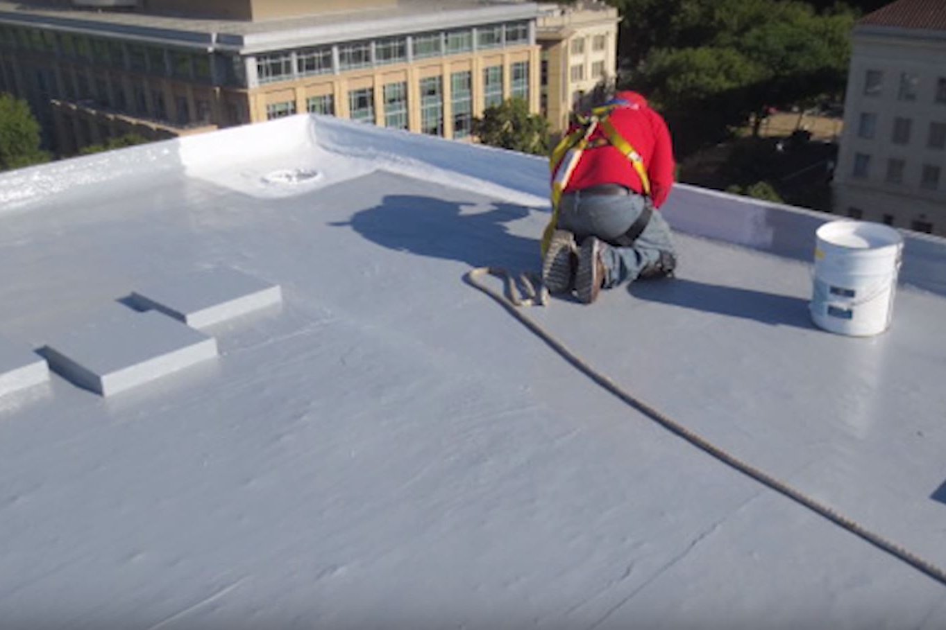 A worker heat-welding seams on a TPO roof during installation